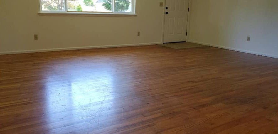 The same hardwood floor after a CCR clean, clean and reflecting the window