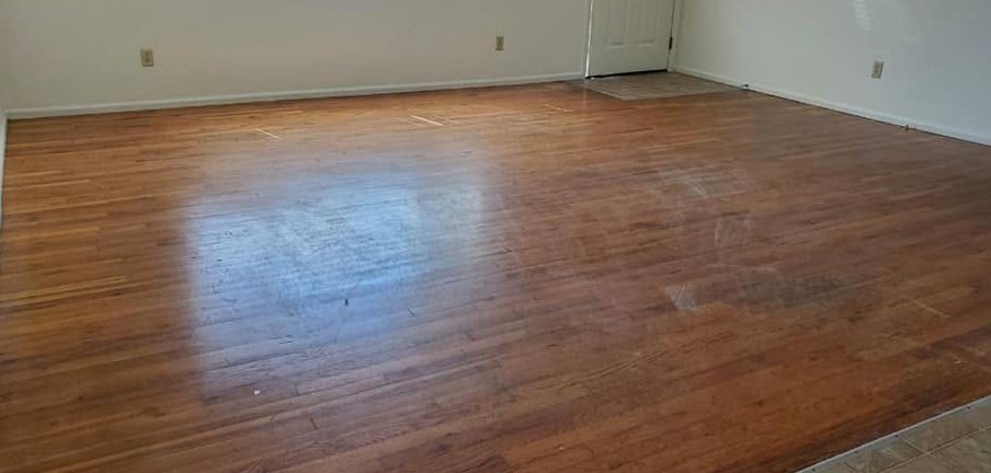A hardwood floor before a CCR clean, dull and marked