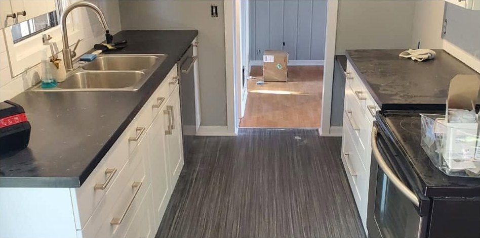 A galley kitchen before a CCR clean, counters covered with items and marks