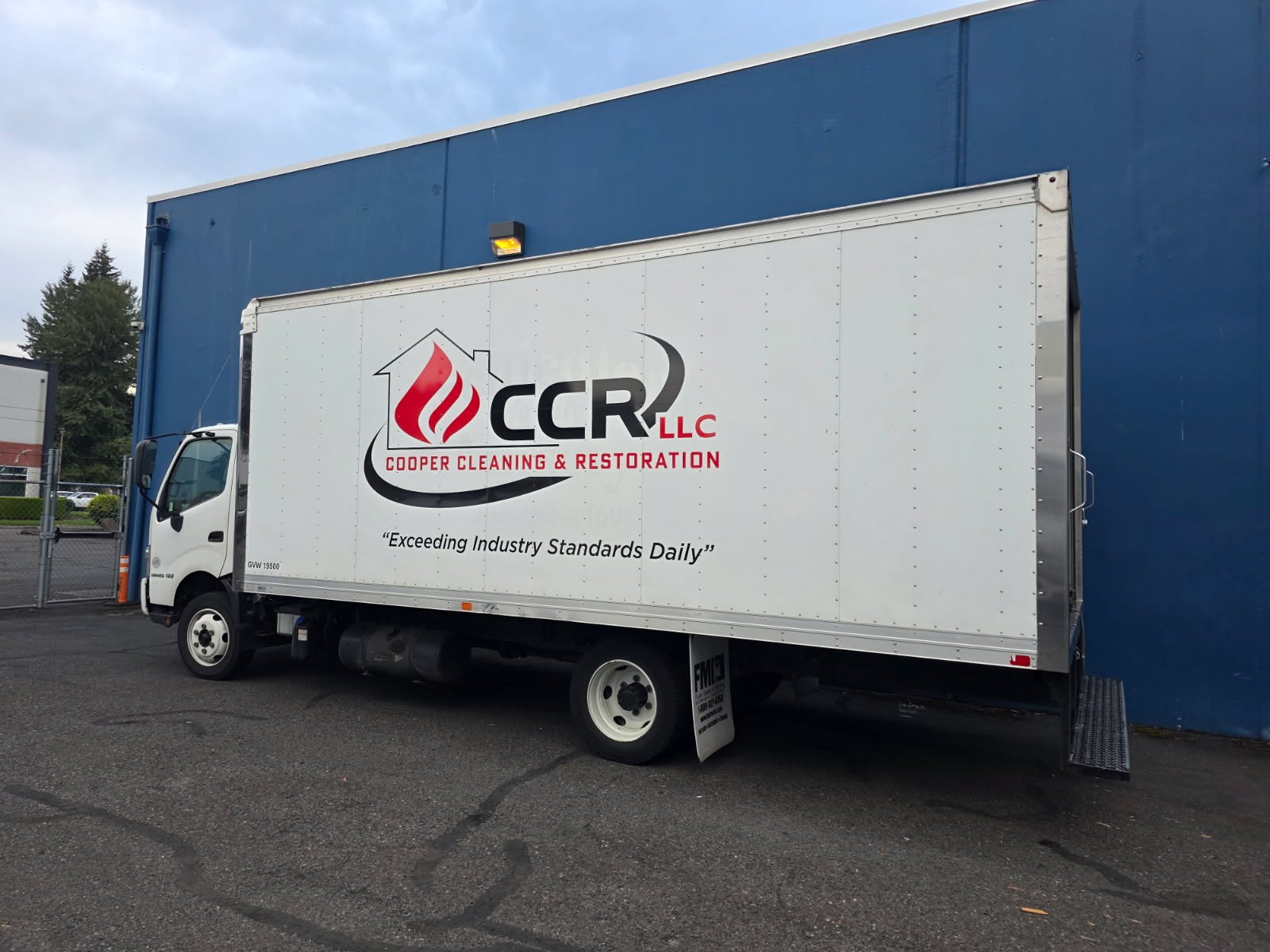 A CCR box truck parked against a blue wall, logo and slogan on the side