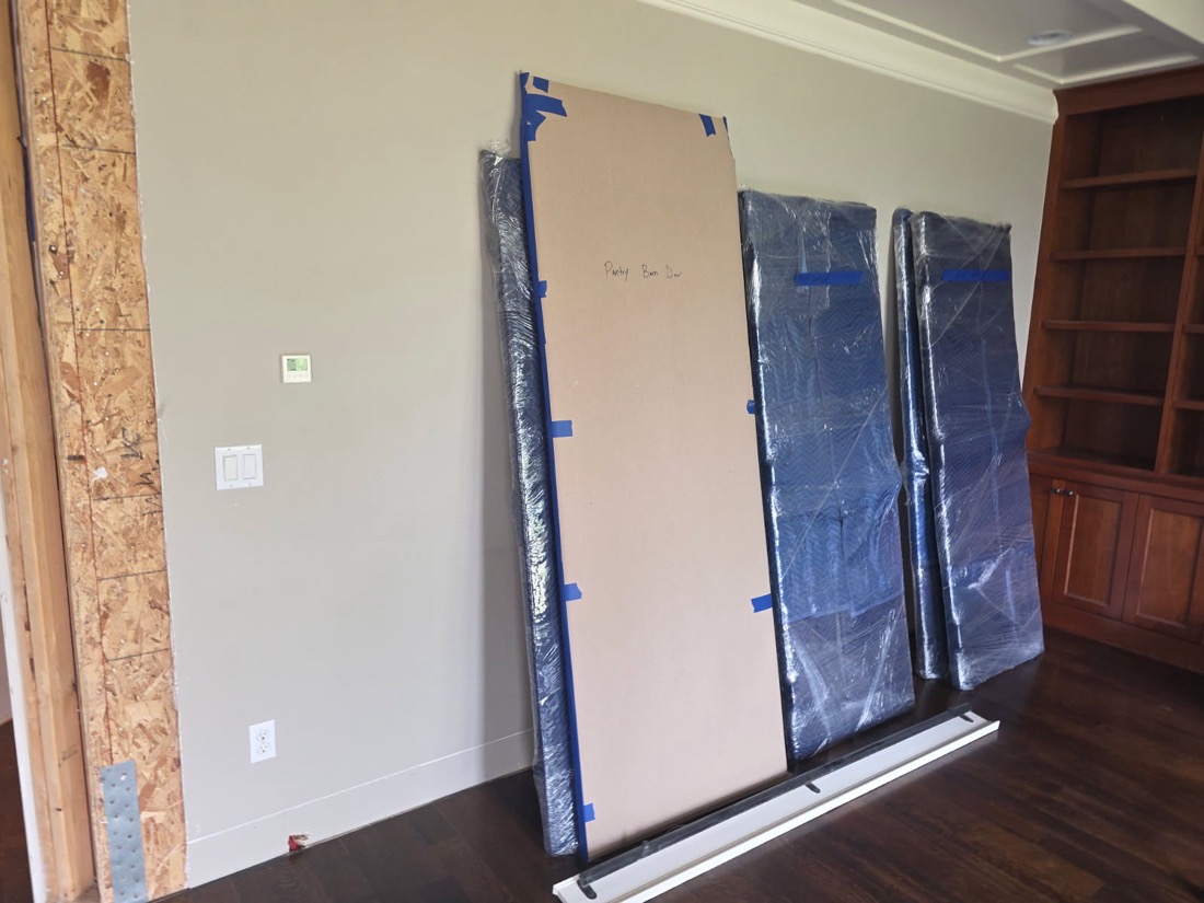 Padded and plastic-wrapped panels stood against a wall on site