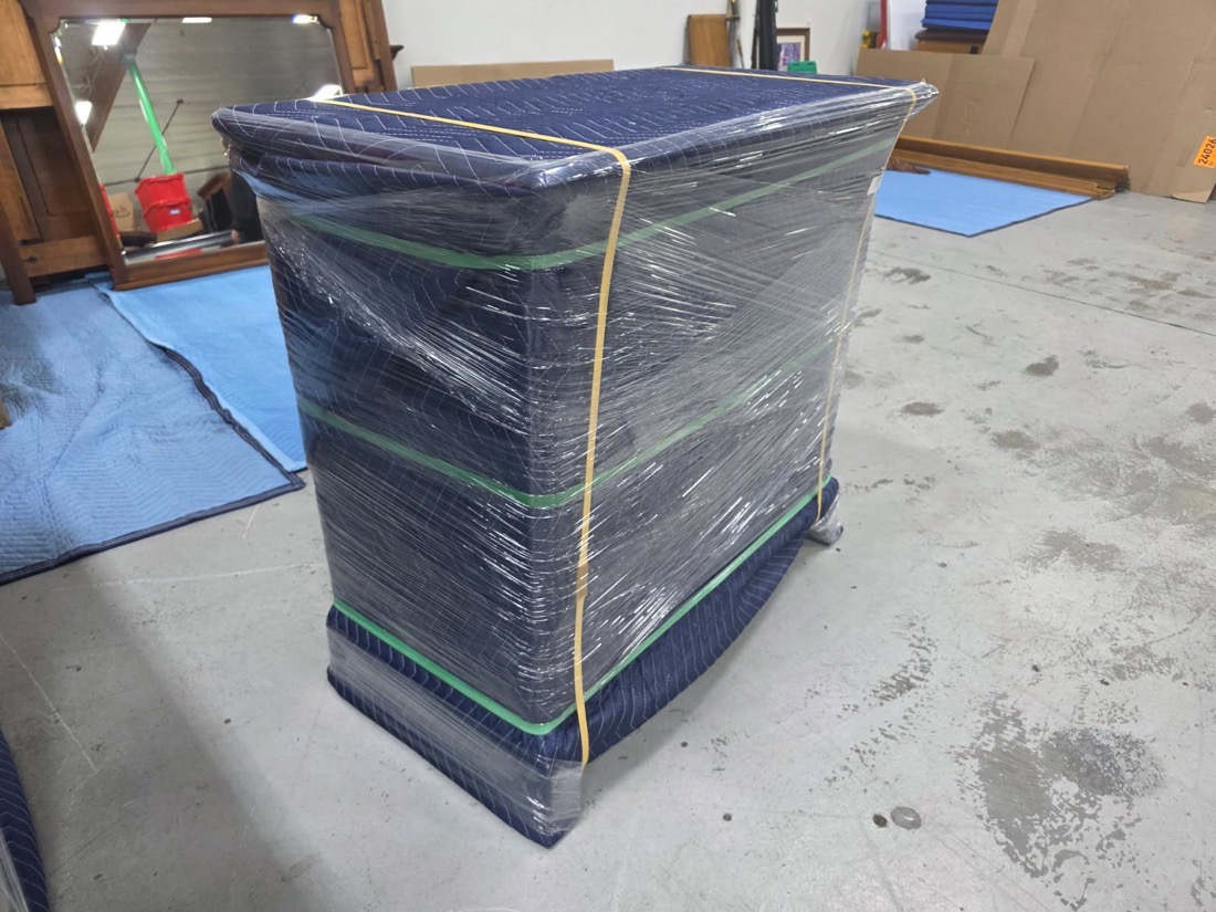 A chest of drawers blanket-wrapped, shrink-wrapped and banded, ready to store at CCR&rsquo;s Vancouver facility