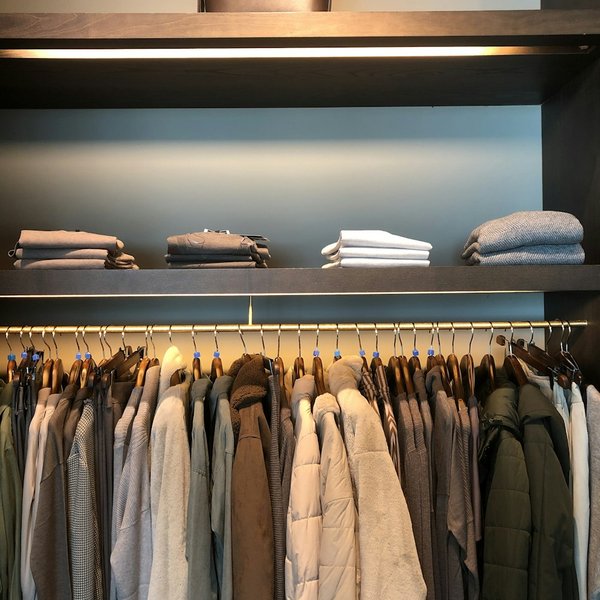 An organized closet with folded shelves above a hanging rail